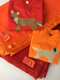 Handmade fleece baby blankets in Red and Bright Orange with matching satin trim. Shown with Baby Fox red t-shirt and Baby Labrador orange t-shirt for babies - isabee.co.uk
