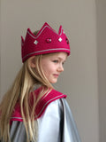 Girl wearing Queen Costume - fuchsia wool felt pointed crown with silver braid and acrylic jewels plus a full-circle silver cape with fuchsia wool felt collar. Dressing up costume for kids. - isabee.co.uk