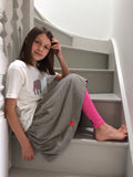 Girl sitting on a grey staircase. She wears a cream coloured t-shirt featuring an appliquéd grey striped elephant, a grey striped skirt (the fabric matches the elephant) and pink leggings. - isabee.co.uk