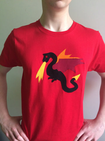 Adult's Red organic cotton T-shirt featuring a Black Appliqué Dragon with fiery red, orange and yellow detailing. T-shirt is worn by a young man with his hands on his hips.- isabee.co.uk