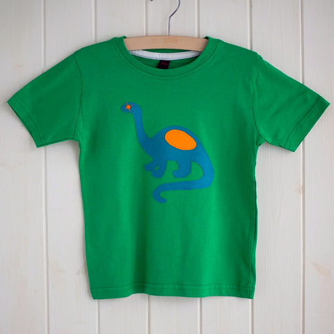 Children's Kelly green cotton t-shirt featuring an appliquéd teal dinosaur with orange details. Dinosaur is reaching its long neck up and the tail is curved around beside. Displayed on a white panelled background. - isabee.co.uk